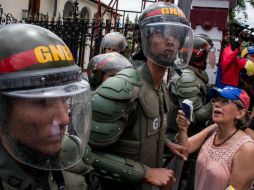 Una mujer grita consignas frente a integrantes de la Guardia Nacional Bolivariana (GNB) durante una manifestación. EFE / M. Gutiérrez