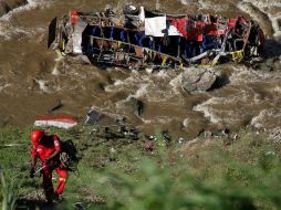Cuerpos policiacos y bomberos trabajan en el lugar para rescatar los cuerpos de las víctimas que cayeron cerca del río Chalhuanca. EFE / ARCHIVO