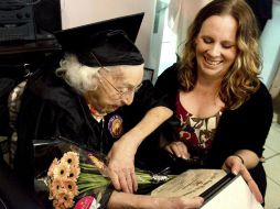 Con toga, birrete y diploma en mano en su asilo de ancianos en Oakdale, Theresia Brandl celebra rodeada de su familia. AP / L. Fong