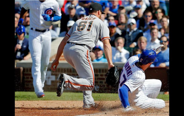 Kris Bryant (#17), de los Cachorros de Chicago, libra el out de Josh Osich (#61), de los Gigantes de San Francisco. AFP / J. Durr