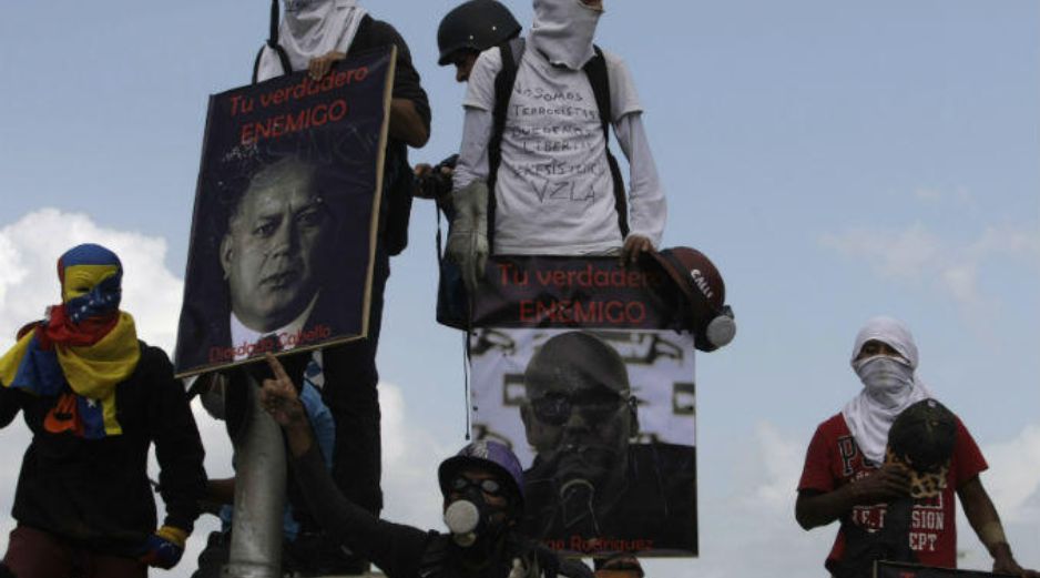 Grupos de jóvenes encapuchados trancaron la principal autopista de la ciudad, al atravesar camiones y armar barricadas. AP / F. Llano