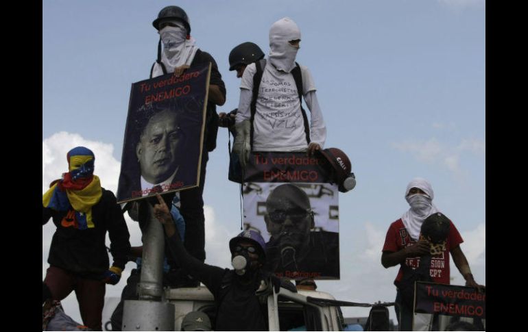 Grupos de jóvenes encapuchados trancaron la principal autopista de la ciudad, al atravesar camiones y armar barricadas. AP / F. Llano