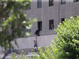 Policías ayudan a escapar a civiles después de que varios hombres armados irrumpieran en el Parlamento iraní. EFE / O. Wahabzadeh