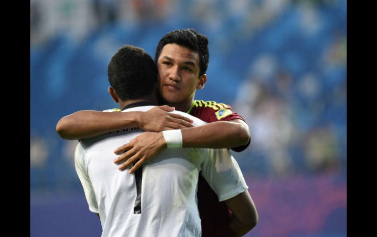 Samuel Sosa abraza a Wuilker Faríñez, quien fue el héroe del partido al atajar dos penaltis. AFP / Y. Lee