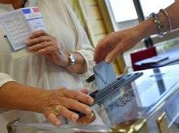 Una mujer deposita su papeleta electoral en un centro de Vertou. AFP / L. Venance