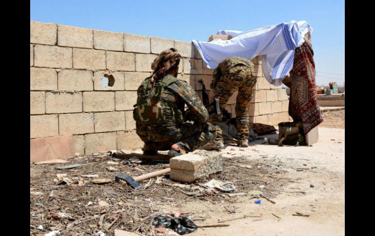 Soldados revisan sus armas tras un muro durante los enfrentamientos entre el Estado Islámico y las FSD. EFE / Y. Rabie
