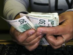 Prevén que el tipo de cambio se ubique entre 17.90 y 18.02 pesos por dólar. AFP / ARCHIVO