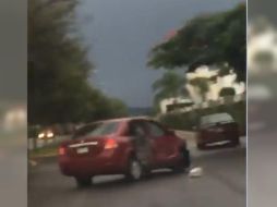 En un video que circula en redes sociales se ve cómo personas afectadas persiguen al conductor de un auto Nissan Tiida tinto. ESPECIAL /