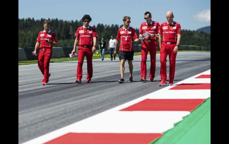 Integrantes de la escudería Ferrari, encabezados por el piloto Sebastian Vettel (centro), recorren el trazado del Red Bull Ring. EFE / C. Bruna