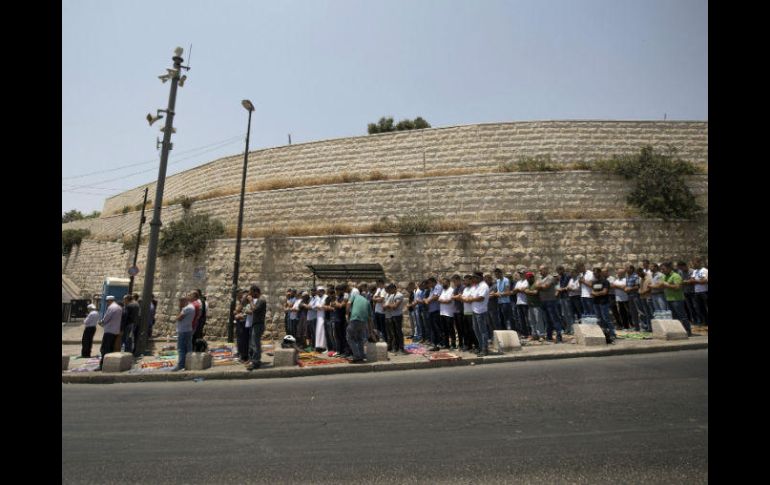 Palestinos rezan en la calle en la Ciudad Vieja en protesta a la instalación de detectores de metales impuesta por Israel. EFE / A. Safati