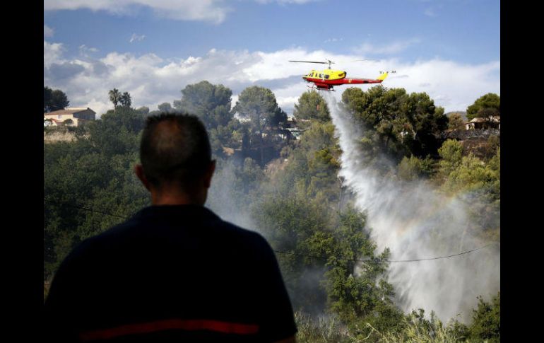 Un helicóptero se suma a las labores de extinción de un incendio en Carros, cerca de Niza. EFE / S. Nogier