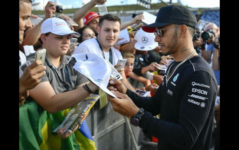 Lewis Hamilton firma autógrafos a los fanáticos que se dieron cita ayer en el Circuito de Hungaroring. AP / Z. Czegledi