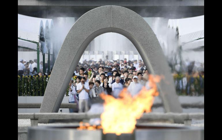 Miles de personas rezan por las víctimas en el Parque de la Paz como parte de la ceremonia. AP / R. Ozawa