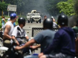 Activistas anti-Gobierno y la Guardia Nacional Bolivariana se enfrentaron ayer tras el ataque en Valencia. AFP / R. Schmidt