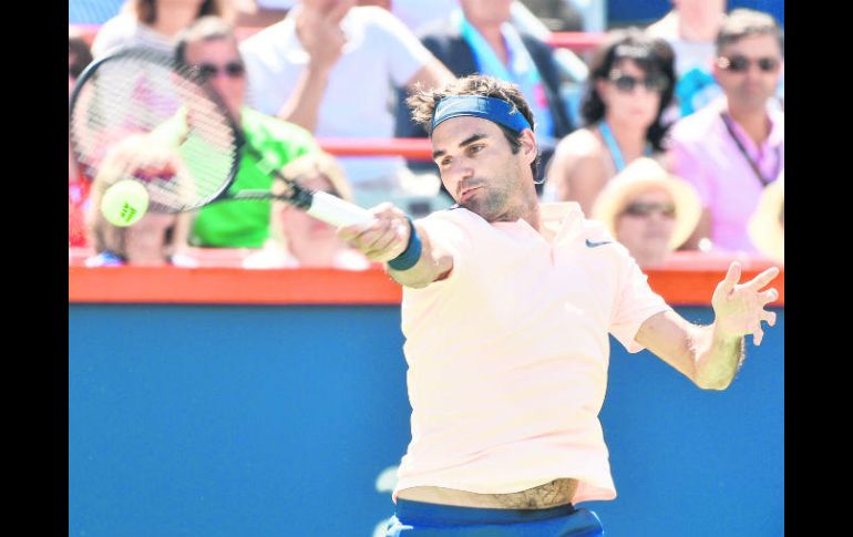 Roger Federer, quien chocará en Octavos de Final con el español David Ferrer, responde una bola al canadiense Peter Polansky. AFP /