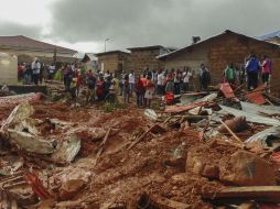 Residentes observan los daños a sus viviendas luego de los deslizamientos de tierra, producto de las fuertes lluvias. EFE / E. Henry