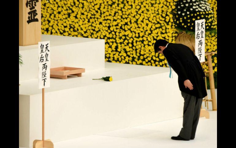 El primer ministro de Japón, Shinzo Abe, se inclina tras colocar una flor en un altar durante la ceremonia. AFP / T. Yamanaka