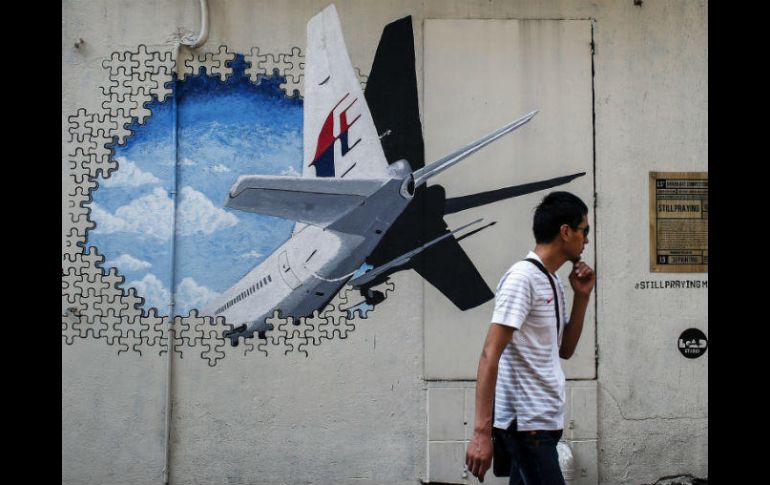 Un hombre camina junto a un mural del vuelo desaparecido de Malaysia Airlines en Shah Alam, a las afueras de Kuala Lumpur. EFE / ARCHIVO