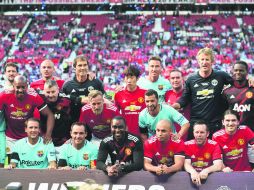 Ex jugadores del Manchester United y del Barcelona posan para una foto después del partido de futbol amistoso entre leyendas. AFP /