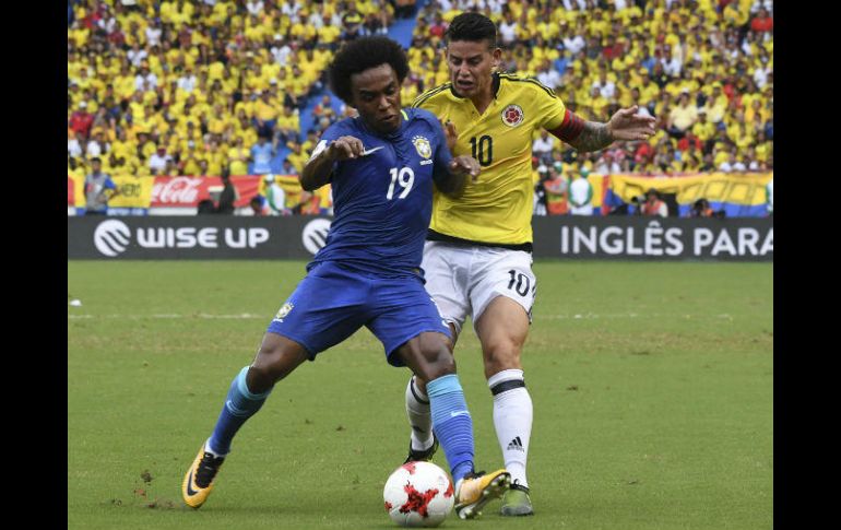 Willian (I), anotador del gol brasileño, disputa un balón con James (D), de Colombia, AFP / L. Acosta