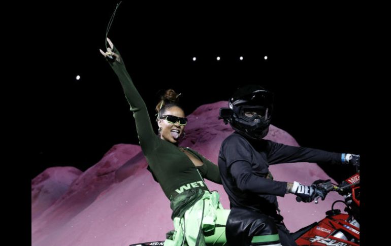 Rihanna montó la parte trasera de una moto, con una mano en alto haciendo la señal de los cuernos y la lengua afuera. EFE / P. Foley