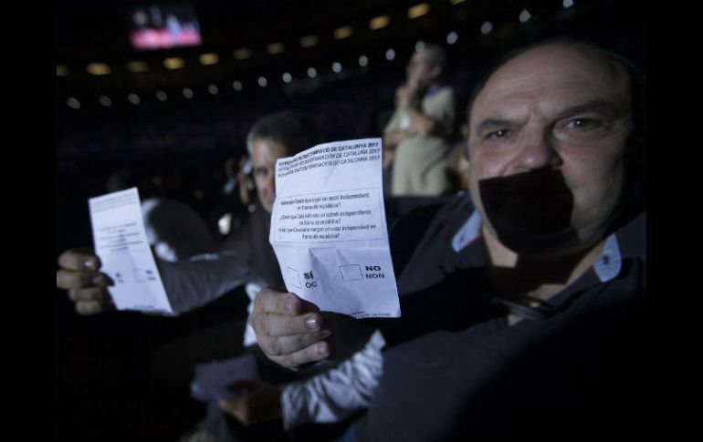 Un activista muestra una papeleta de votación del próximo referéndum durante un acto a favor de la independencia de Cataluña. NTX / A. Salamé