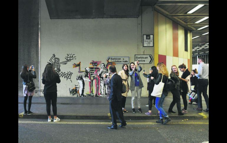 Obra. Ciudadanos toman fotografías de una pieza del artista Banksy, en Londres (Reino Unido). EFE /