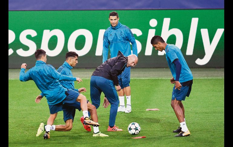 Zinedine Zidane (c) disputa el balón con sus pupilos del Real Madrid durante el entrenamiento de ayer de cara a su próximo partido.
