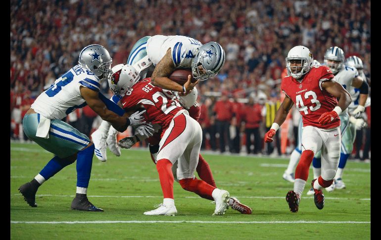 A las diagonales. El quarterback de Dallas, Dak Prescott (#4), salta para llegar a la zona de anotación.