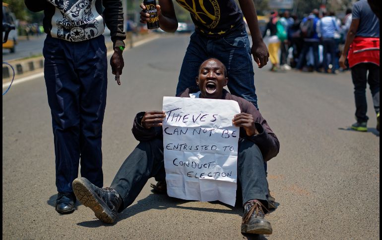NAIROBI, KENIA.- Un manifestante de oposición sostiene un letrero alusivo a los oficiales de la comisión electoral. AP/B. Curtis
