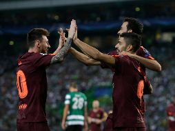 Suárez (D), abrazado por Busquets, celebra tras propiciar el autogol del club lisboeta. AP/ A. Franca
