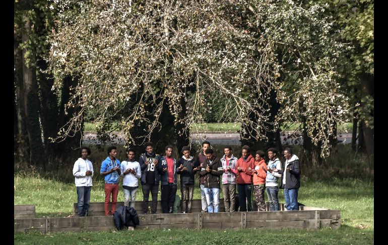 Migrantes musulmanes se reúnen para las oraciones de la tarde en Calais, Francia. AFP/P. Huguen