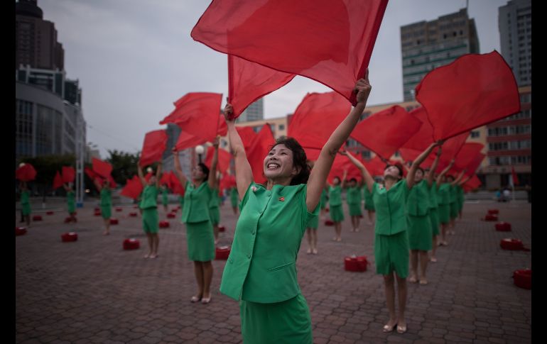 Un grupo de propaganda presenta una rutina afuera de la estación central de trenes en Pyongyang, Corea del Norte. AFP/E. Jones