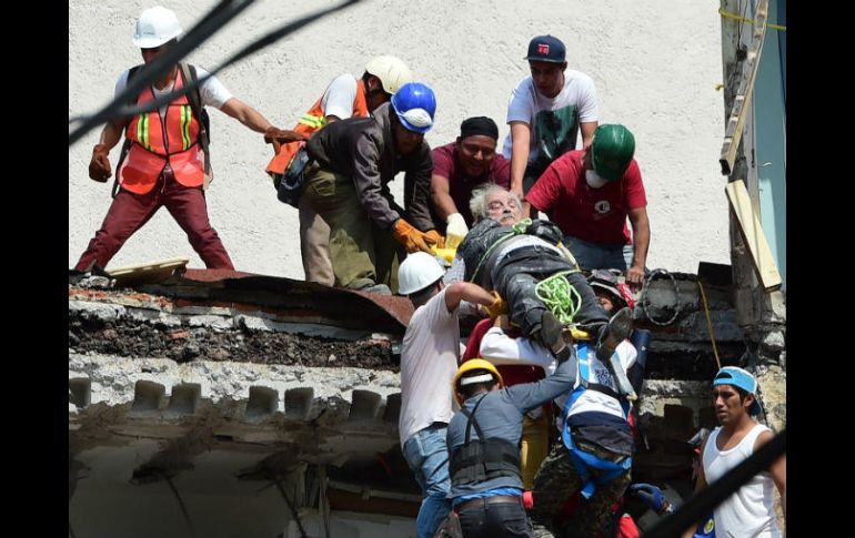 Un hombre es rescatado de un inmueble colapsado. AFP / R. Schemidt