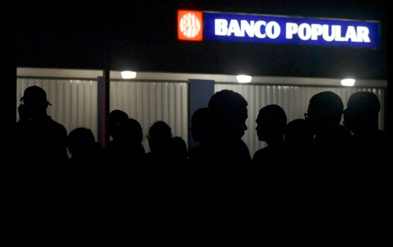 Puertorriqueños hacen fila para un cajero automático en la oscuridad luego de que la mayor parte de la isla se ha visto privada de suministro eléctrico.