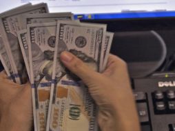 El billete verde se compra en un mínimo de 17.05 pesos. AFP / ARCHIVO