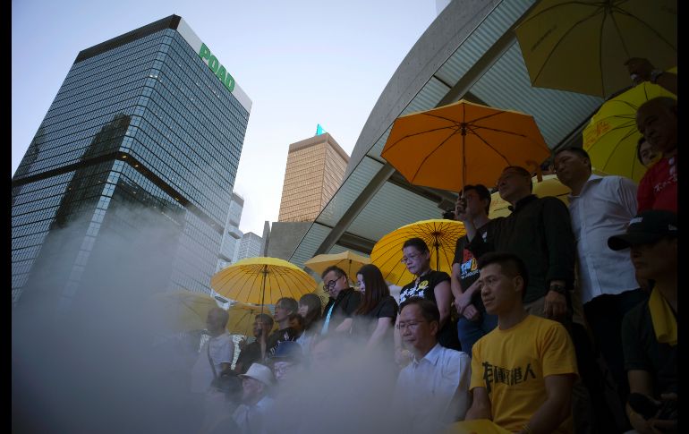 Activistas prodemocracia, con sus icónicos paraguas amarillos, protestan afuera de las oficinas del gobierno en Hong Kong, China, en el tercer aniversario del movimiento civil 