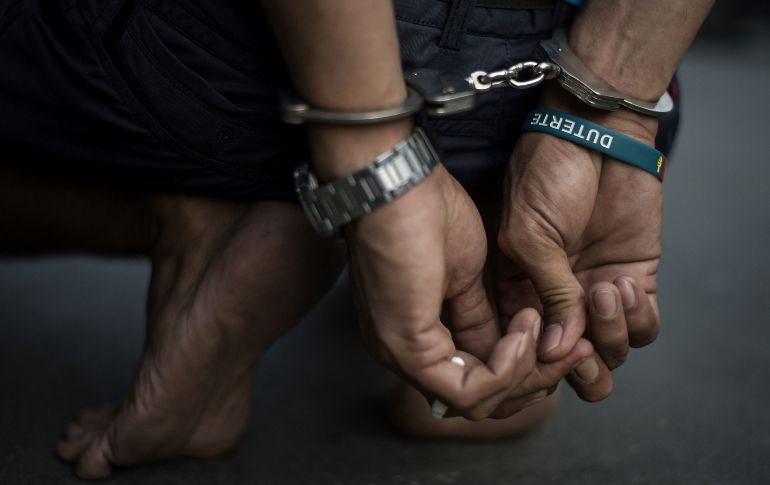 Un presunto narcotraficante es detenido por policías tras un operativo en un barrio de Manila. El presidente Rodrigo Duterte comenzó a aplicar su campaña antidroga al llegar al poder, en junio de 2016. AFP/N. Celis