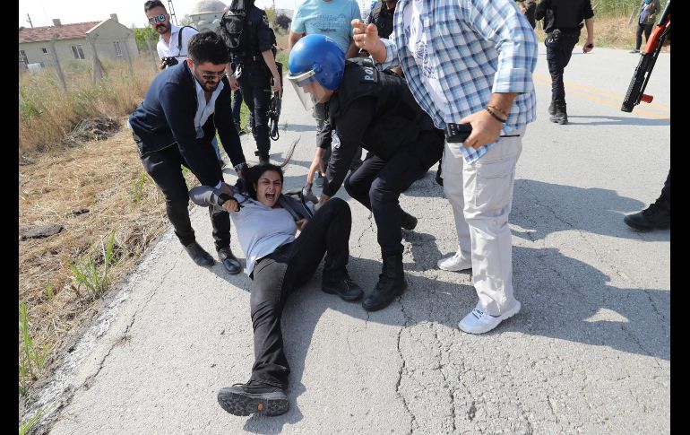 Un policía detiene en Ankara a una manifestante que apoya a los educadores Nuriye Gulmen y Semih Ozakca, quienes están en huelga de hambre desde marzo, tras ser despedidos como parte de la purga contra el intento del golpe de estado. AFP/A. Altan