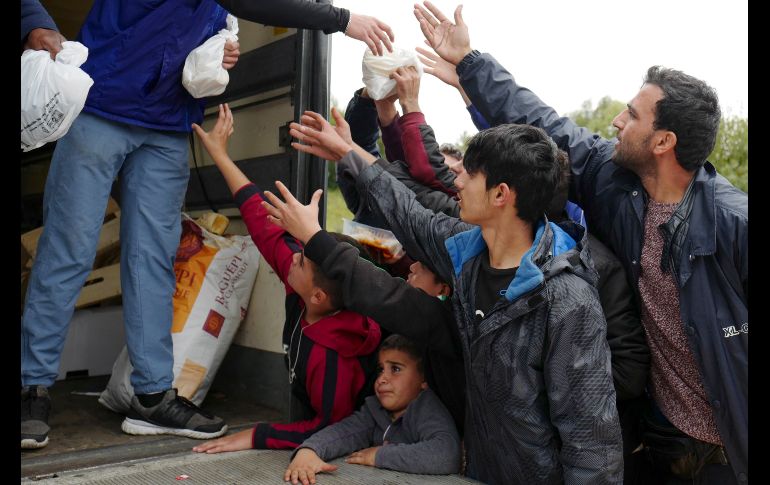 Migrantes del Kurdistán iraquí reciben alimentos de parte de la organización no gubernamental Emmaus en Grand-Synthe, Francia. Un refugio en el sitio alberga a unos mil 500 migrantes. AP/M. Spingler