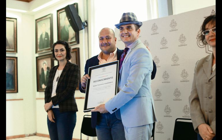 Honores. Enrique Alfaro (a la izquierda) entrega el reconocimiento a Ismael García Ávila, director del ensamble. EL INFORMADOR/G. Gallo