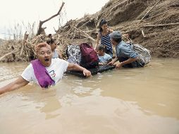 Río San Lorenzo Morovis. Una familia regresa a en Morovis, después del paso de “María”. AP