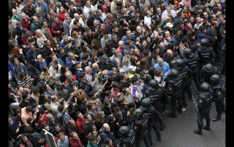 Agentes antidisturbios de la Policía Nacional forman un cordón de seguridad en los alrededores del colegio Ramón Llull de Barcelona. EFE/A. Estévez