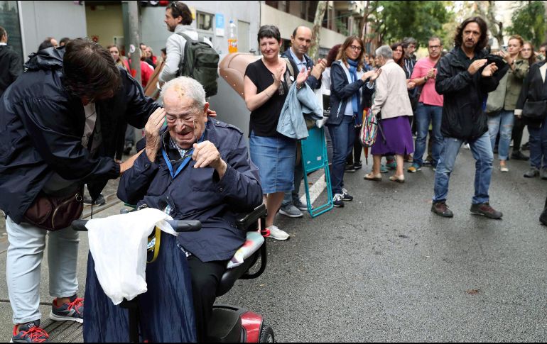 Por otro lado, un votante independentista es aplaudido al salir de las urnas. EFE / T. Albir