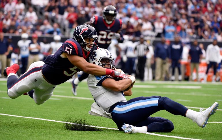 Marcus Mariota (d), de los Titanes de Tennessee y Dylan Cole, de los Texanos de Houston, en una jugada de la primera mitad del partido de la NFL en Houston. AFP/E. Smith