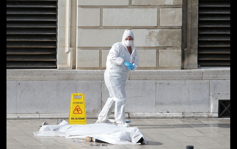 Un policía investiga junto a un cuerpo en Marsella, Francia, luego de que un hombre atacó con un cuchillo en la estación principal de trenes. Al menos dos hombres murieron y el atacante fue abatido. AP/C. Paris