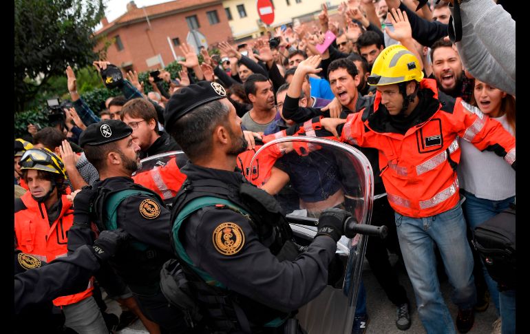 Bomberos intentan contener a votantes.