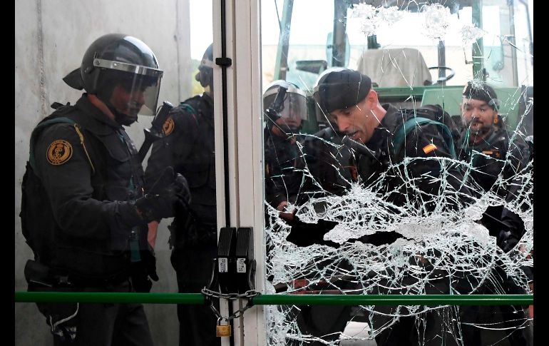 Elementos de la Guardia Civil rompen una puerta en un lugar de votación en Sant Julia de Ramis.