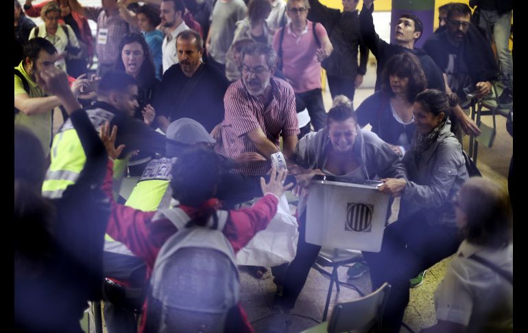 Elementos de la Policía vestidos de civiles retiran urnas.