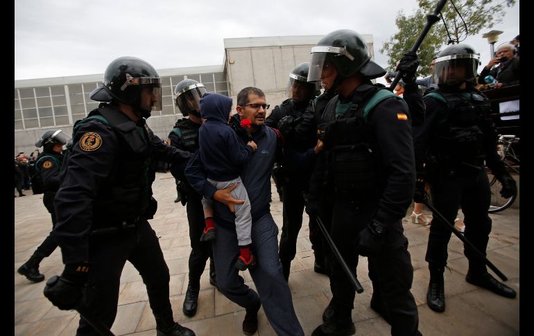 Guardias civiles fuerzan a un hombre con un niño a retirarse.